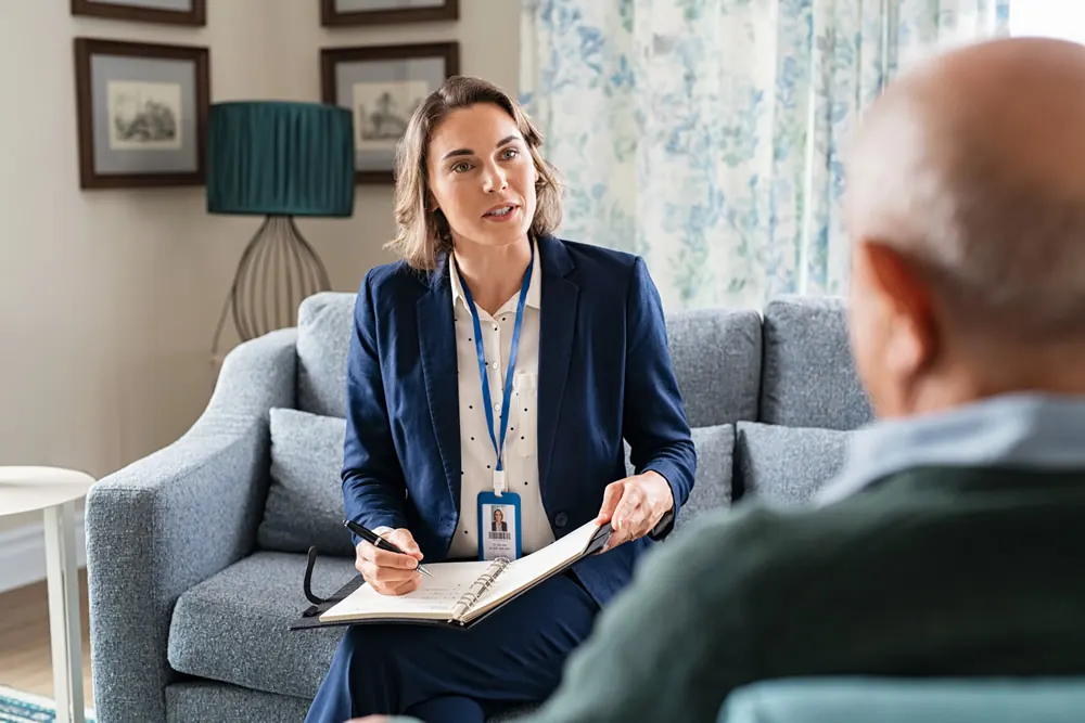 An adviser taking notes with an older man at home