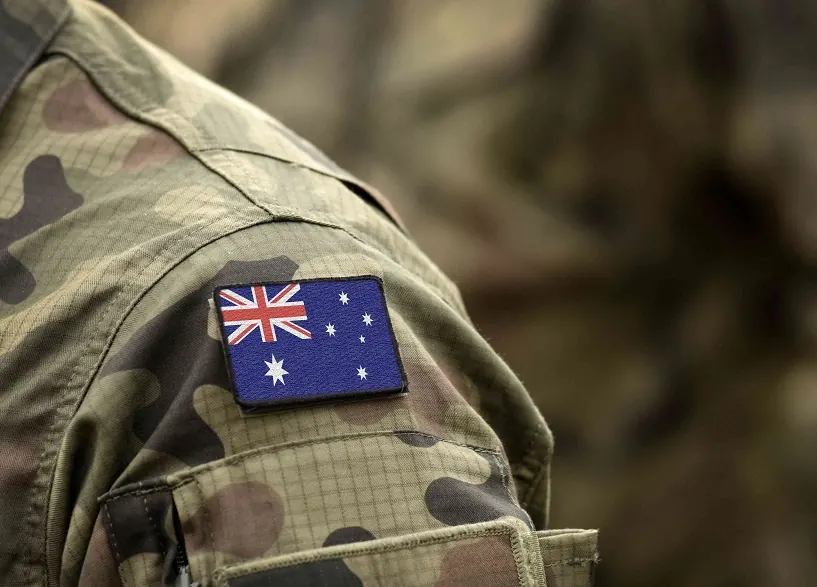 An Australian flag patch on a camouflage uniform