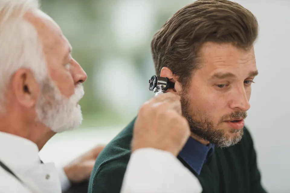 A doctor checking a man’s ear