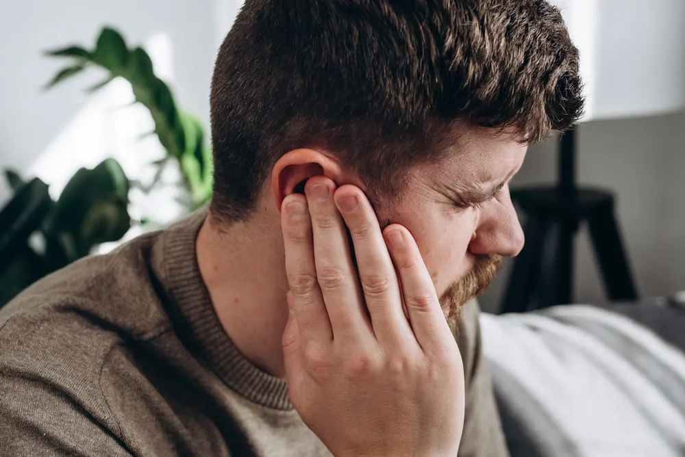 A man holding his hand to his ear