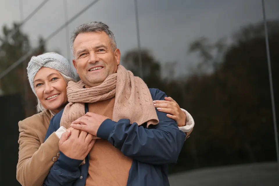 An older couple smiling together outdoors
