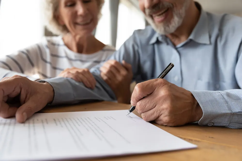 An older couple signing paperwork