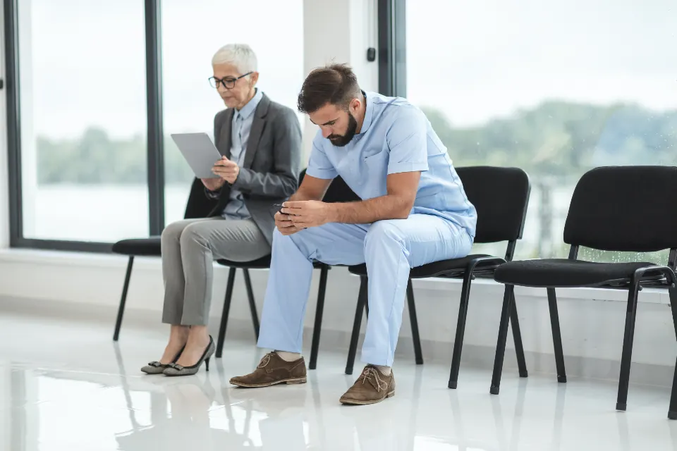 A nurse sitting with a patient in a waiting area