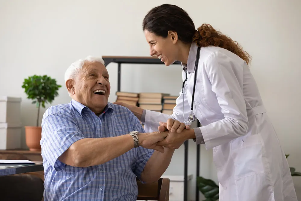 An older man laughing with his doctor