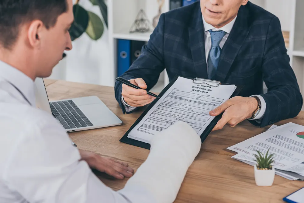 Two people signing documents at a desk