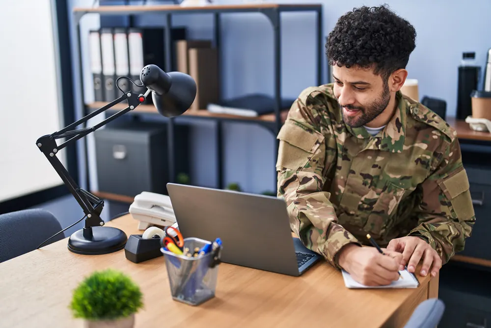 A man in uniform working on a laptop