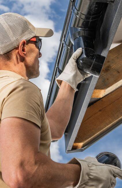 AusVeterans coordinates DVA gutter cleaning to help veterans maintain safe, functional homes. Worker inspecting roof drainage as part of gutter cleaning household services.