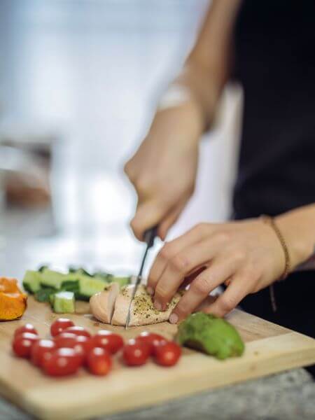 Support worker preparing a healthy meal with fresh ingredients, representing in-home DVA meal preparation services coordinated by AusVeterans.